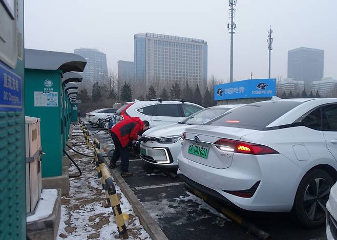 중국 베이징의 전기차 충전소에서 한 남성이 전기차를 충전하고 있다. /김남희 특파원