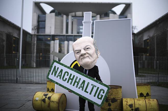 지난 11일(현지시각) 독일 베를린의 총리관저 앞에서 올라프 숄츠 총리의 가면을 쓴 환경단체 소속 활동가가 \