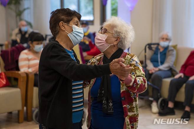 [네타니아=AP/뉴시스] 5일(현지시간) 이스라엘 네타니아의 한 사립 요양원에서 화이자 백신 4차 접종을 기다리는 할머니들이 춤을 추고 있다. 이스라엘 정부는 전염력이 강한 오미크론 변이로 신규 감염자 수가 사상 최대를 기록했다고 밝혔다. 2022.01.06.