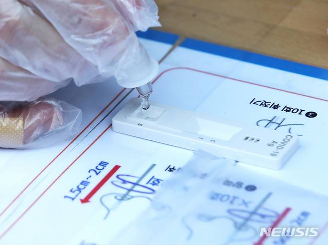 [서울=뉴시스] 조수정 기자 = 29일 오전 서울 종로구 보건소 코로나19 선별진료소 신속항원 검사소에서 시민이 자가진단키트로 검사를 하고 있다.  설 연휴 첫날인 이날 0시기준 코로나19 신규 확진자는 1만 7542명으로 연일 역대 최다를 경신하고 있다. 서울시는 오미크론 확산 대비 검사인원 수용을 위해 29일부터 보건소 25곳과 직영 검사소 4곳에서 신속항원검사용 자가진단키트를 무료 제공한다. 오는 3일부터는 60세 이상 고위험군을 제외하고는 모두 자가진단키트를 사용해야 한다. 2일까지는 PCR검사와 자가진단키트 중 선택할 수 있다.  2022.01.29. chocrystal@newsis.com