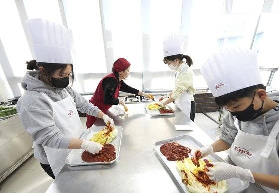 김인아·정가희·박경원(왼쪽부터) 학생기자가 곽 명인의 도움을 받아 배추김치를 담그고 있다.