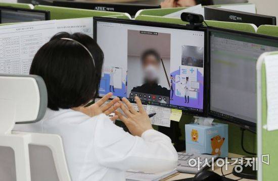 지난 19일 경기도 성남시의료원 재택치료 상황실에서 관계자가 '팍스로비드'를 복용하며 재택치료를 하고 있는 환자의 증세 등을 화상전화를 이용해 체크하고 있다.