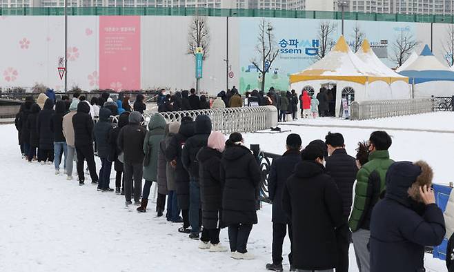 설날 아침 서울 송파구 올림픽공원에 마련된 임시선별검사소에서 시민들이 줄을 서서 검사 순서를 기다리고 있다. 연합뉴스