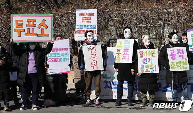 장애인차별금지추진연대 등 장애인 관련 단체 회원들이 지난달 18일 서울 서초구 서울중앙지법 서문 앞 삼거리에서 발달장애인의 공직선거 정보 접근권 보장을 위한 차별 구제 청구 소송을 제기하기에 앞서 열린 기자회견에서 발달장애인 참정권 보장을 요구하는 퍼포먼스를 하고 있다. 2022.1.18/뉴스1 © News1 박지혜 기자