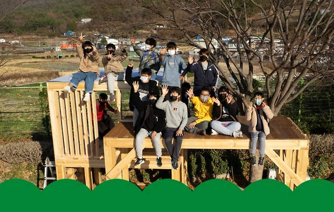 경남 남해 상주초등학교 6학년 학생들이 지난해 12월 7일 운동장 벚나무 아래에 만든 비밀 기지에 올라가 손을 흔들고 있다. | 채용민 PD