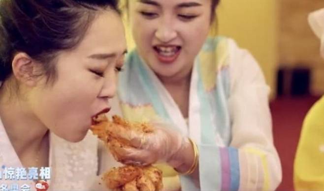 조선족 여성이 서로 김치를 먹여주는 모습. 이 모습은  올림픽 개막 사전 행사에 나왔지만 중계되지는 않았다. (출처: 지린성 홍보 영상)