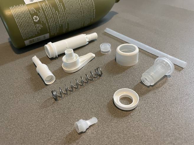 샴푸통을 분해하니 펌핑 뭉치에서만 10개 부품이 나왔다. 환경부가 배포하는 분리배출 가이드라인에는 ‘펌핑식 용기의 부속품(노즐, 스프링 등)은 별도 배출하라’고 돼 있다. 일반 쓰레기 봉투에 넣어 버리라는 얘기다. [최준선 기자]