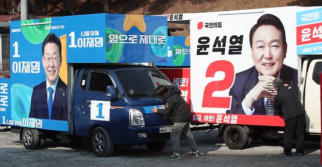 제20대 대통령선거 공식선거운동을 앞둔 14일 충남 금산에 위치한 차량광고업체에서 관계자들이 이재명 더불어민주당 대선 후보와 윤석열 국민의힘 대전 후보의 선거운동 유세차량을 제작하고 있다. /뉴스1