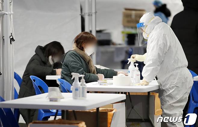 코로나19 신규 확진자 수가 9만 443명으로 폭증해 10만 명대를 눈앞에 둔 16일 오후 서울 송파구 잠실종합운동장에 마련된 신종 코로나바이러스 감염증(코로나19) 임시 선별진료소에서 시민들이 신속항원검사를 받고 있다. 코로나 확진자 수는 오미크론이 우세종으로 자리 잡은 이후 1월 중순부터 4주 연속, 두 배씩 증가하는 '더블링 현상'이 이어지더니 하루 10만 명대 코앞까지 오며, 다음달 초에는 하루 20만 명에서 정점을 찍을 거라고 전문가들은 예상하고 있다. 2022.2.16/뉴스1 © News1 김진환 기자