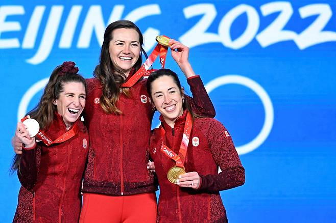 이자벨 웨이드먼(가운데)을 비롯한 캐나다 스피드스케이팅 여자 팀 추월 대표팀이 금메달을 목에 걸고 웃고 있다. [AFP=연합뉴스]