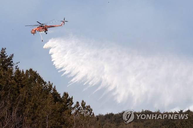 물 뿌리는 헬기 (영덕=연합뉴스) 손대성 기자 = 16일 경북 영덕군 영덕읍 산에서 불이 번져 헬기가 물을 뿌려 불을 끄고 있다. 2022.2.16 sds123@yna.co.kr