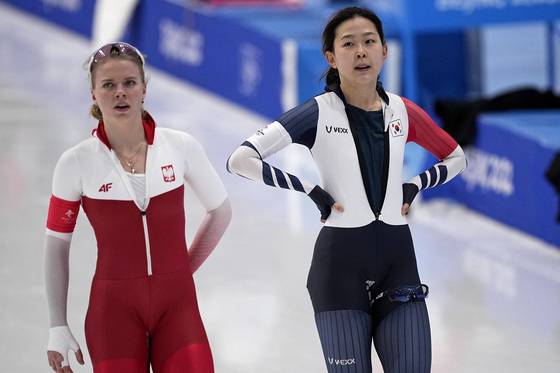 Kim Min-sun, right, and Karolina Bosiek of Poland react after their heat in the women's speedskating 1,000-meter finals at the 2022 Winter Olympics on Thursday. [AP/YONHAP]