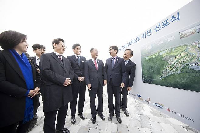 2019년 11월 21일 오후 화성시 송산그린시티 내 동측 부지에서 열린 화성국제테마파크 비전 선포식에서 이재명 경기도지사와 홍남기 경제부총리, 정용진 신세계그룹 부회장, 서철모 화성시장, 이학수 한국수자원공사 사장, 송옥주 국회의원 등이 시화지구 사업현황 및 국제테마파크 조감도 등을 보며 이야기를 나누고 있다. /경기도 제공