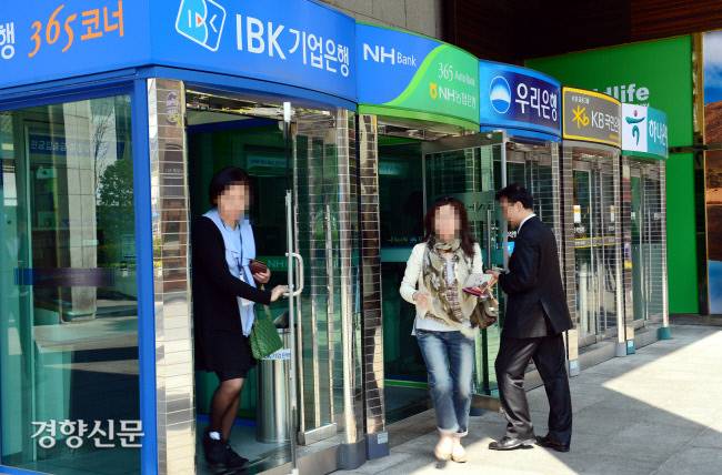 시민들이 현금입출금기에서 은행업무를 처리하고 있다(사진은 기사와 직접 관련이 없음). 경향신문 자료사진