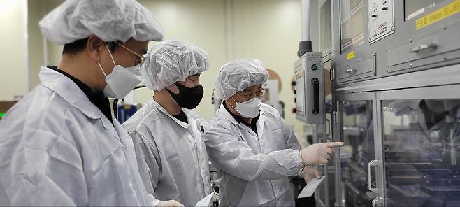 충남 천안에 있는 자가 진단 키트 생산업체 '젠바디'에서 삼성전자 스마트 공장 전문가와 젠바디 직원(가운데)이 자가 진단 키트 조립 라인을 점검하고 있다./사진=삼성전자