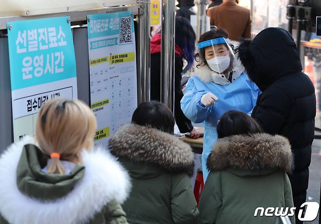20일 오전 서울 중구보건소 코로나19 선별진료소에서 한 의료진이 시민들에게 검사안내를 하고 있다.  2022.2.20/뉴스1 © News1 박세연 기자