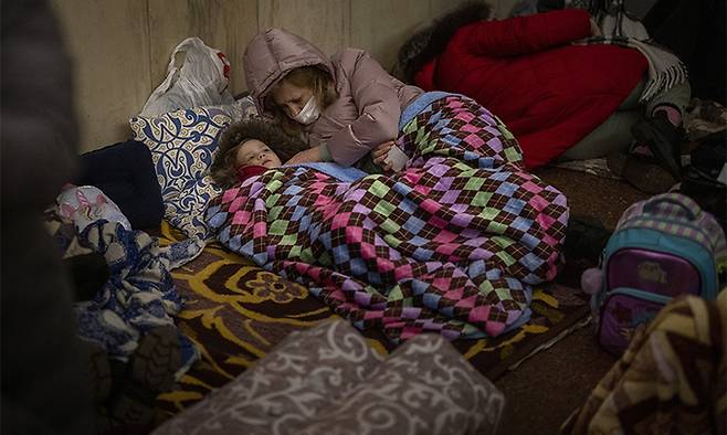 지난 24일(현지시간) 우크라이나 수도 키예프에서 폭격을 피해 지하철로 피신한 시민들이 새우잠을 자고 있다. 키예프=AP연합뉴스