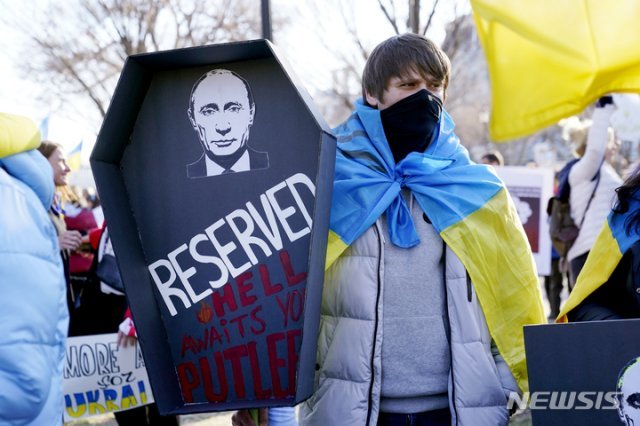 27일(현지시간) 워싱턴 백악관 밖에서 러시아의 우크라이나 침공에 반대하는 시위에 참여한 한 남성이 블라디미르 푸틴 러시아 대통령의 사진이 담긴 관을 들고 있다. 워싱턴=AP/뉴시스