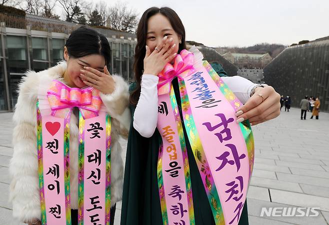 [서울=뉴시스] 백동현 기자 = 이화여대 20221학년도 전기 학위수여식이 개최된 28일 오후 서울 서대문구 이화여자대학교에서 한 졸업생이 '졸업선물은 남자친구'라는 문구를 목에 걸고 있다. 2022.02.28. livertrent@newsis.com