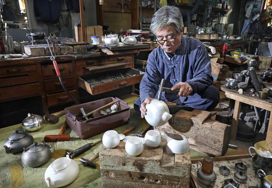 Master metal craftsman Hong Jae-man works on a silver kettle at Uno Silver Studio in Ojeong-dong in Bucheon, Gyeonggi. [PARK SANG-MOON]