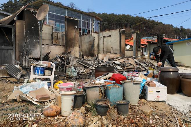 경북 울진군 북면 고목리에서 6일 한 남성이 화재로 전소된 집 마당에서 수도꼭지를 틀어보고 있다. | 이준헌 기자