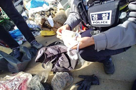 지난 5일 충남 부여경찰서 규암파출소 직원들이 쓰레기더미 속에서 할머니가 천에 싸아 보관하던 현금을 발견했다. [사진 충남경찰청]