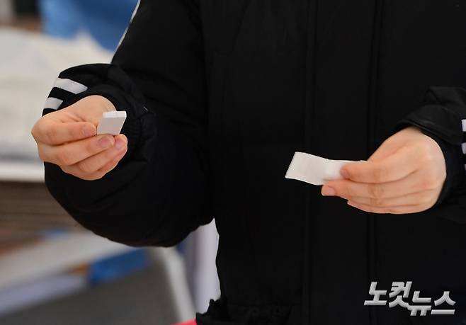 신속항원검사를 마친 한 시민이 의료진에게 키트를 제출하고 있다. 황진환 기자