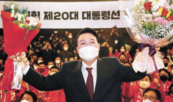 윤석열 대통령 당선인이 10일 새벽 서울 여의도 국회도서관에 마련된 '국민의힘 제 20대 대통령선거 개표상황실'을 찾아 축하 꽃다발을 받고 있다. 윤 당선인은 이번 대선에서 1639만4815표를 얻어 1987년 직선제 이후 대선 최다 득표로 당선됐다. 김경록 기자
