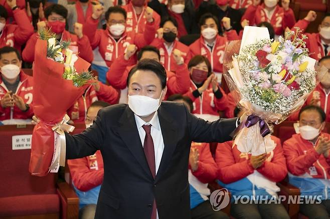 꽃다발 든 윤석열 당선인 (서울=연합뉴스) 윤석열 제20대 대통령 당선인이 10일 새벽 서울 여의도 국회도서관에 마련된 '국민의힘 제 20대 대통령선거 개표상황실'에서 꽃다발을 들고 포즈를 취하고 있다. 2022.3.10 [국회사진기자단] photo@yna.co.kr