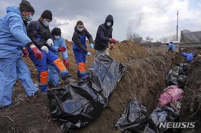 [마리우폴=AP/뉴시스] 9일(현지시간) 우크라이나 마리우폴 외곽에서 주민들이 러시아군의 포격으로 숨진 사람들의 시신을 집단 매장하고 있다. 마리우폴은 일주일 전부터 전기와 수도가 끊긴 것으로 알려졌다. 2022.03.10.