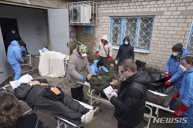 [마리우폴=AP/뉴시스] 9일(현지시간) 우크라이나 마리우폴 외곽에서 주민들이 러시아군의 포격으로 숨진 사람들의 시신 집단 매장 준비를 하고 있다. 마리우폴은 일주일 전부터 전기와 수도가 끊긴 것으로 알려졌다. 2022.03.10.
