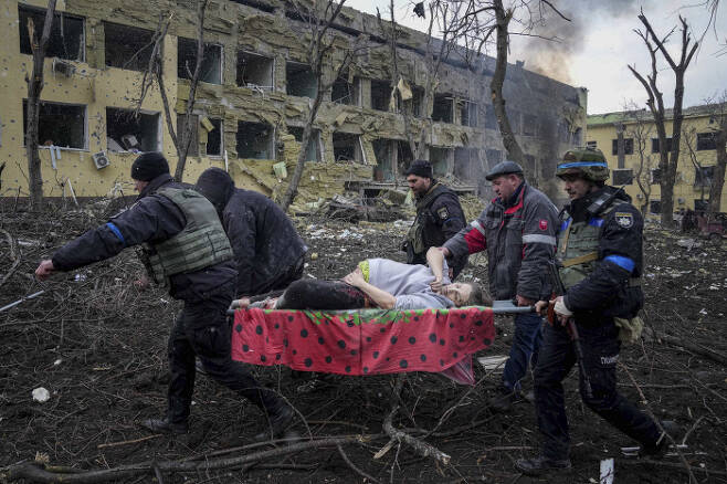 우크라이나 응급구조대와 자원봉사자들이 3월 9일 러시아의 폭격으로 파괴된 산부인과 병원에서 부상당한 임산부를 옮기고 있다.   AP연합뉴스