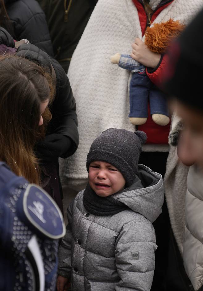 한 여성이 3월 5일 우크라이나와 폴란드 국경 지역의 메디카에서 우는 아이를 달래고 있다.   AP연합뉴스