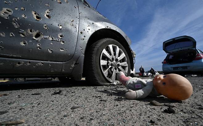 우크라이나 키이우 인근 이르핀에서 총탄 흔적이 남는 승용차와 길에 떨어진 인형의 모습. 3월 12일 촬영.(사진=AFP 연합뉴스)
