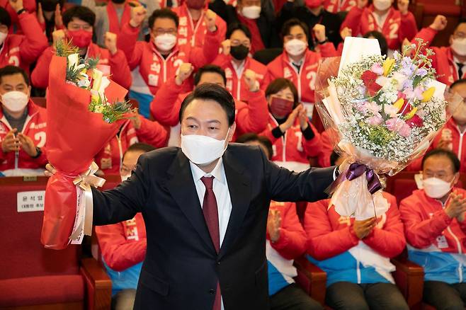 윤석열 제 20대 대통령 당선인이 지난 3월 10일 새벽 서울 여의도 국회 도서관에 마련된 개표상황실에서 꽃다발을 들고 있다./뉴스1
