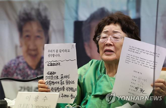 '위안부 피해자들의 목소리를 담아' (서울=연합뉴스) 이지은 기자 = 일본군 위안부 피해자 이용수 할머니가 17일 오전 서울 중구 프레스센터에서 일본군 '위안부' 문제 ICJ 회부 추진위원회 주최로 열린 각국 '위안부' 생존자 및 단체의 유엔 인권 특별보고관 공개서한 발송 발표 기자회견에서 공개서한과 직접 적은 입장문을 들어보이고 있다. 2022.3.17 jieunlee@yna.co.kr