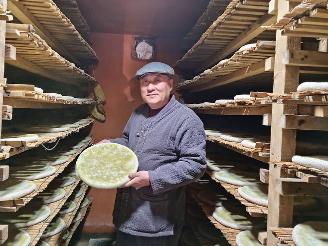 금정산성 막걸리 유청길 대표가 누룩방에서 발효가 거의 끝난 누룩을 들어보이고 있다. 국내 유일의 수제 누룩방인 이곳은 연탄불로 온도를 조절한다. /박순욱 기자