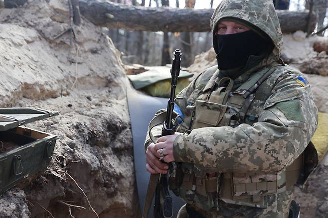 우크라이나 병사가 진지에서 소총을 든 채 대기하고 있다. AP 통신