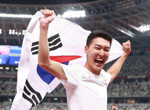 육상 국가대표 우상혁이 지난 2021년 8월 도쿄 올림픽스타디움에서 열린 2020 도쿄올림픽 남자 높이뛰기 결승전 경기에서 4위 2.35 한국신기록을 달성한 뒤 태극기를 들어보이고 있다. 우상혁은 20일 세르비아 베오그라드 스타크 아레나에서 열린 2022 세계실내육상선수권대회 남자 높이뛰기에서 금메달을 획득했다. /사진=뉴시스