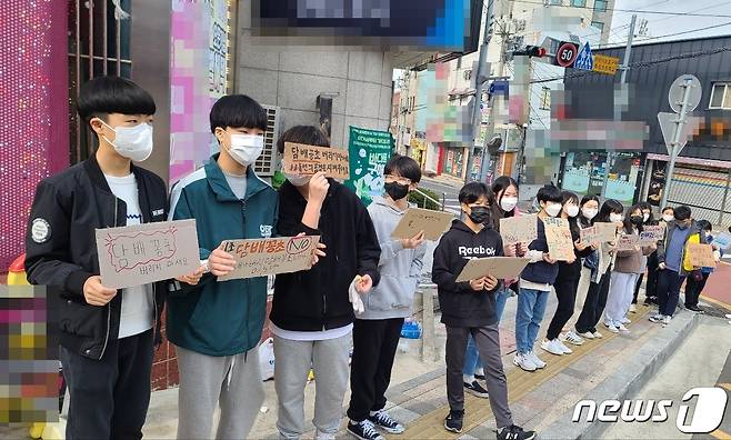 부산 영도희망청소년봉사단이 피켓을 들고 담배꽁초 줄이기 캠페인을 하고 있다.2022.3.20. © 뉴스1 손연우기자