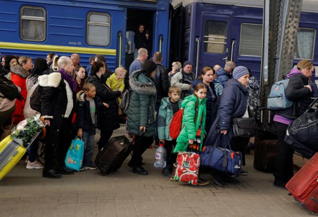 러시아군의 공격을 피해 피란 중인 우크라이나인들이 22일 서부 르비우 기차역에서 이동하고 있다. 르비우=로이터 연합뉴스