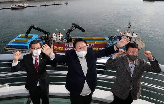 지난해 12월 11일 윤석열 당선인이 강원 속초시 대포항 다리에 올라 어민들의 환영 현수막에 손 흔들며 화답한 뒤 포즈를 취하고 있다. 왼쪽은 이양수 의원. 연합뉴스