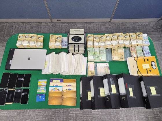 경찰이 압수수색을 통해 확보한 현금과 장부, 대포폰, 대포통장 등. [부산경찰청 제공]
