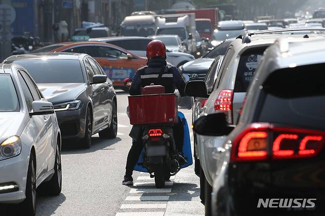 [서울=뉴시스] 권창회 기자 = 경찰이 이륜차의 중앙선 침범행위에 과태료 7만원을 부과하는 처벌규정을 신설할 계획이다. 경찰청은 도로교통법 시행령 및 시행규칙 개정안을 입법예고하고, 오는 12월 6일까지 국민 의견을 수렴할 예정이다. 27일 오후 서울 시내 한 거리에서 오토바이가 중앙선 위에서 신호대기를 하고 있다. 2021.10.27. kch0523@newsis.com