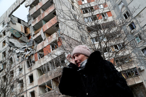 지난 17일 마리우폴에서 러시아군의 포격에 박살이 난 아파트의 주민으로 보이는 여성이 눈물을 훔치고 있다. 사진=AP 연합뉴스