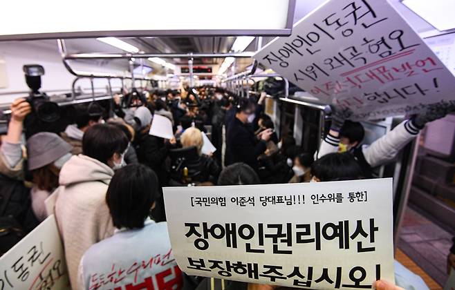전국장애인차별철폐연대(전장연) 회원들과 시민단체가 28일 서울 3호선 지하철 전동차 안에서 장애인 이동권 보장·장애인 권리 보장 예산 반영을 요구하며 출근 시간대 지하철 시위 ‘출근길 지하철 탑니다’를 하고 있다. 2022.3.28 연합뉴스