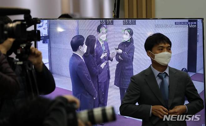 [서울=뉴시스] 배훈식 기자 = 한덕수 국무총리 후보자가 4일 오전 서울 종로구 한국생산성본부 빌딩에 마련된 청문회 준비단 사무실로 첫 출근을 하며 취재진의 질문에 답하는 모습이 체온측정 화면에 나오고 있다. (공동취재사진) 2022.04.04. photo@newsis.com