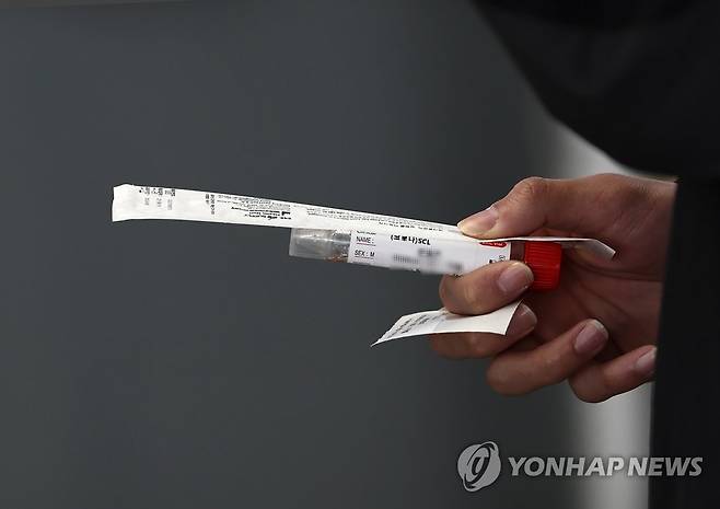 오늘도 검사 (서울=연합뉴스) 윤동진 기자 = 10일 중구 서울역 임시 선별검사소에서 한 시민이 코로나19 검사 채취 키트를 들고 대기하고 있다. 2022.4.10 mon@yna.co.kr