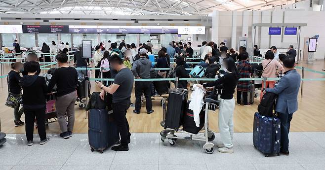 지난 11일 인천국제공항 제1터미널 출국장에서 비행기에 탑승하려는 출국자들이 탑승 수속을 위해 줄을 서고 있다. [연합]
