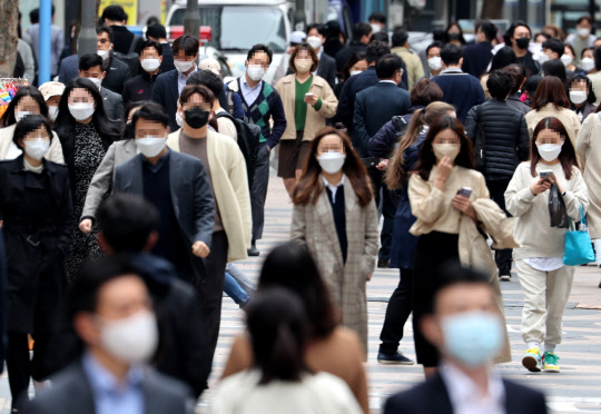 정부가 대규모 집회·행사를 제외한 일반적인 상황에서 야외 마스크 착용 의무를 없애는 방안을 논의 중인 가운데 14일 서울 명동거리에서 시민들이 마스크를 쓴 채 걸어가고 있다.   연합뉴스